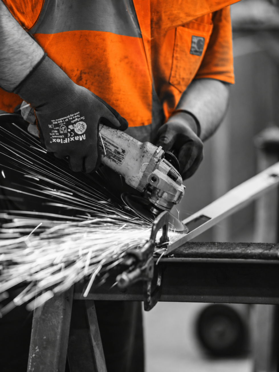 Relay Labour worker operating an angle grinder with sparks flying